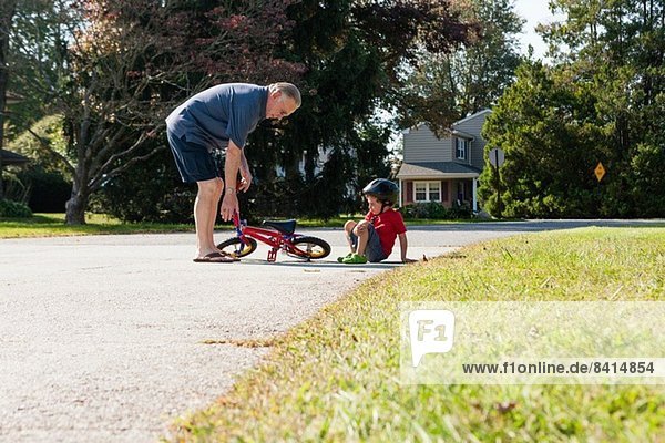 Großvater holt Fahrräder für kleine Jungen ab.