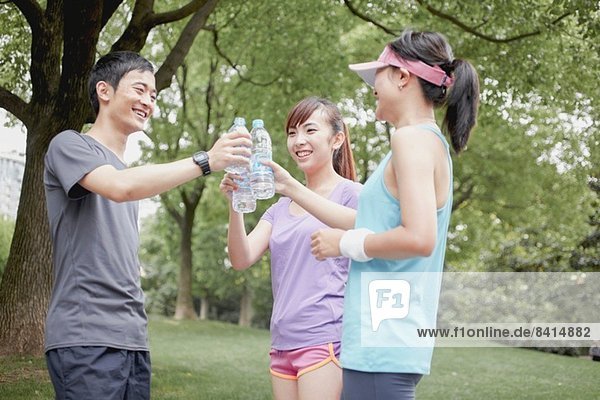 Joggerfreunde teilen sich das Wasser im Park