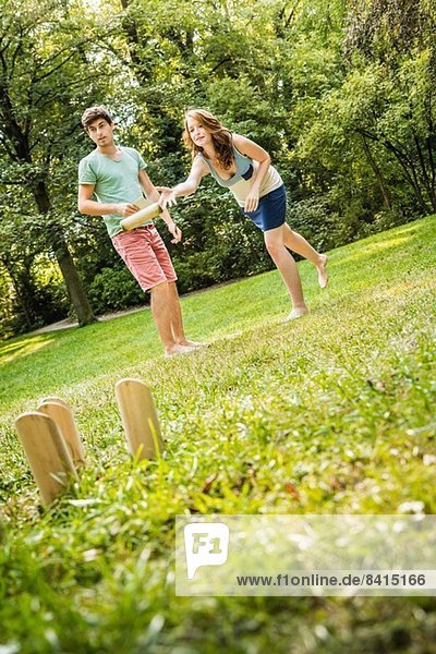 Junges Paar spielt Molkky im Park