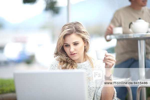 Junge Frau im Café mit Kaffee  mit Laptop