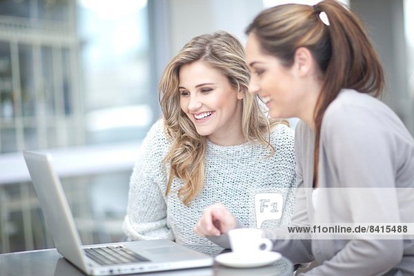 Young women at cafe with coffee  using laptop