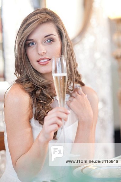 Porträt einer jungen Frau mit einem Glas Champagner