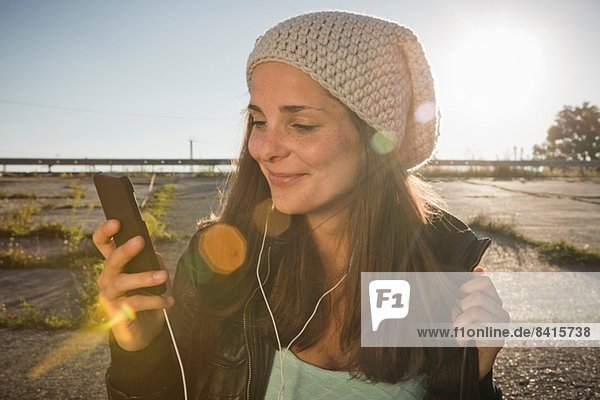 Young woman wearing earphones listening to music
