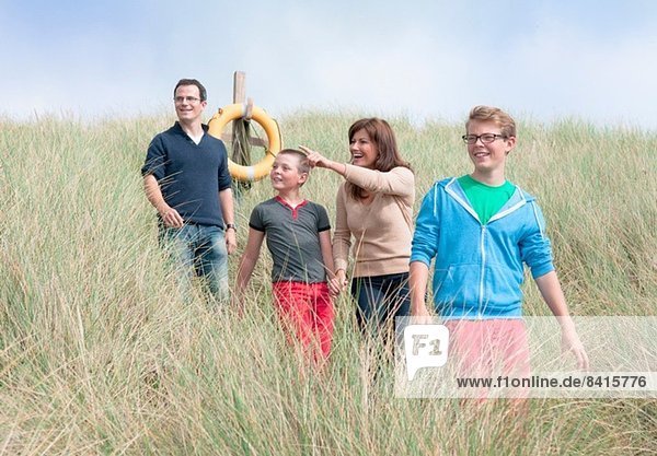 Family strolling in sand dunes