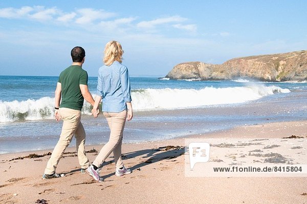 Mid adult couple walking on beach  Thurlestone  Devon  UK