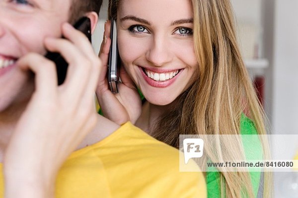 Teenager-Mädchen am Handy mit Mann im Vordergrund