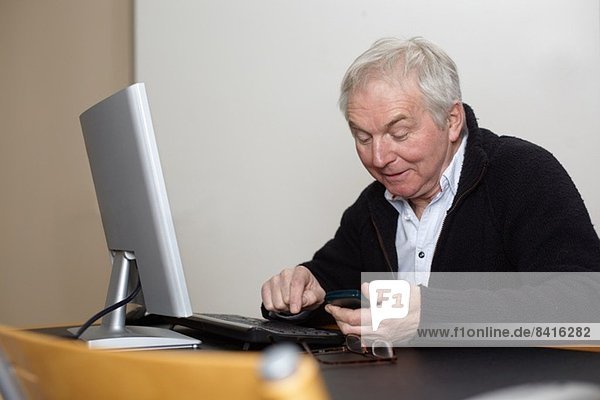 Senior Mann zu Hause mit Personal Computer