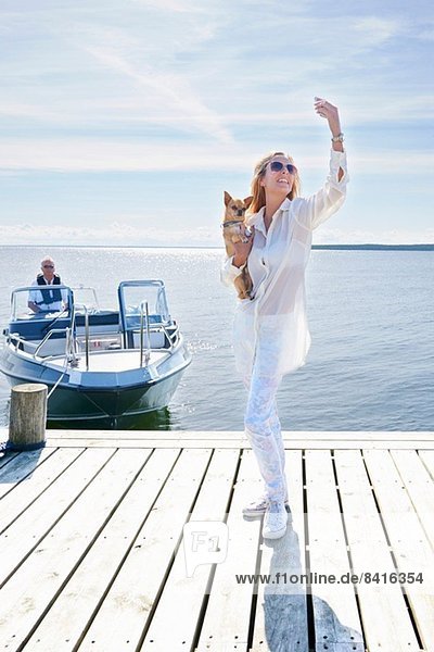Junge Frau fotografiert sich mit Hund am Pier  Gavle  Schweden