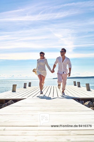 Junges Paar hält sich an der Pier  Gavle  Schweden