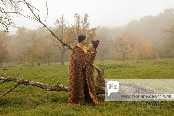 Junges Paar in Decke gewickelt im Nebelpark