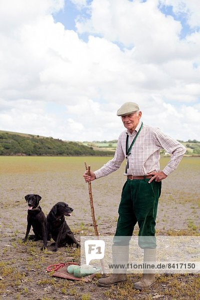 Porträt eines älteren Mannes mit zwei schwarzen Labradoren