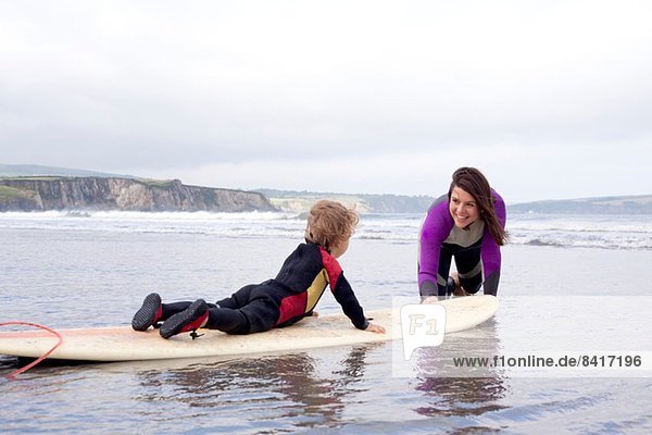 Mutter lehrt Sohn  wie man surft