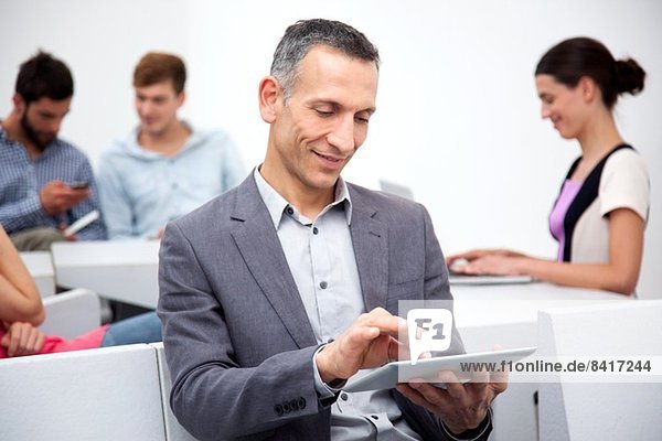 Reifer Mann mit digitalem Tablett
