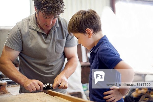 Vater zeigt Sohn Schreinerei in der Bootswerkstatt