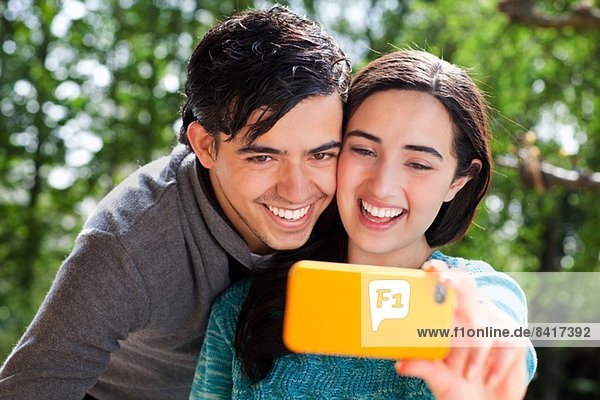Portrait of young couple taking self portrait in garden