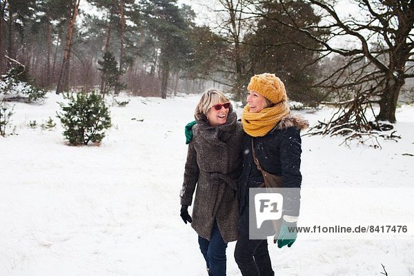 Mother and daughter walking in snow