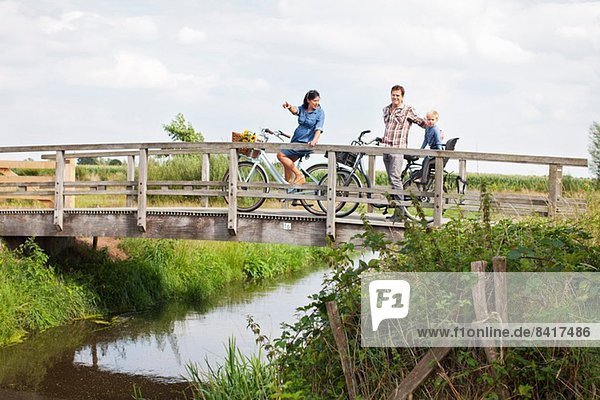 Familienradfahren über Holzbrücke