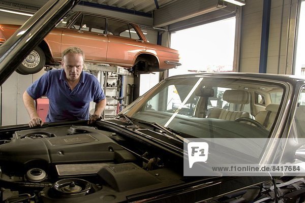 Mechanic repairing car in workshop