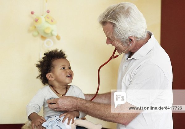 Pädiater untersucht kleines Mädchen mit Stethoskop