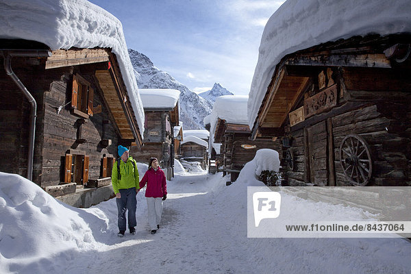 Frau Winter Mann gehen folgen Weg Dorf wandern 2 Wegweiser Wanderweg Schnee Wintersport