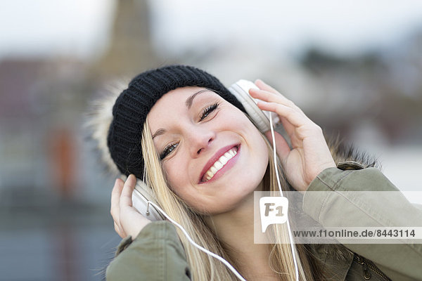 Portrait of smiling young woman with headphones  close-up