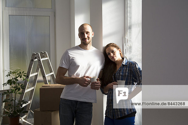 Young couple moving into new home  taking a coffee break