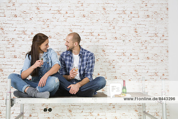 Young couple moving into new home  drinking champagne