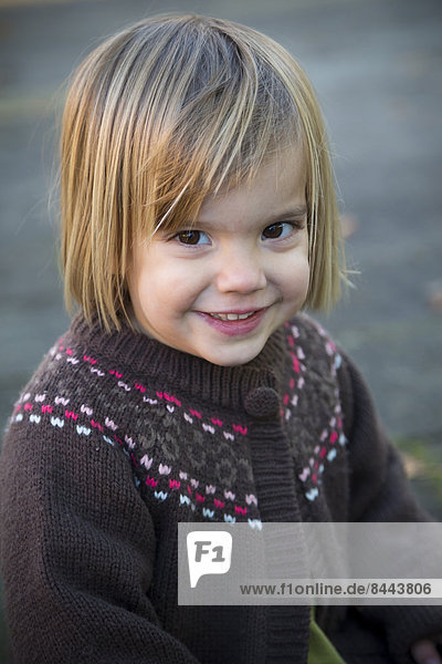 Portrait of smiling little girl wearing cardigan