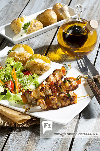 Chicken meat sticks with baked potatoes and mixed salad