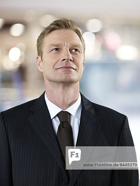 Portrait of smiling businessman looking up