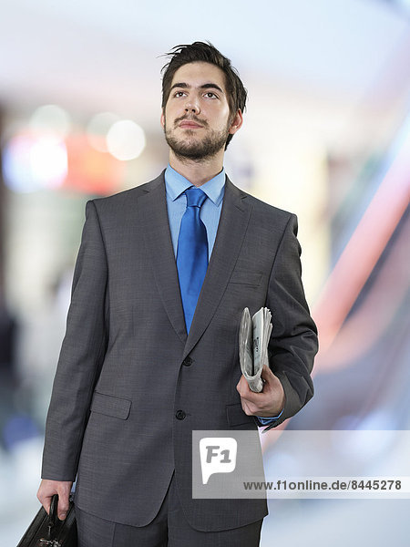 Portrait of businessman with briefcase and newspaper