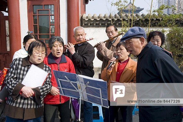 People gather to form an informal choir  part of the morning exercise in the park by the City Wall  Xian  China