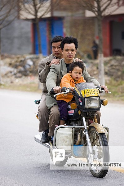 Men and child on a motorbike in Guilin  China. China has a one child family planning policy to reduce population.