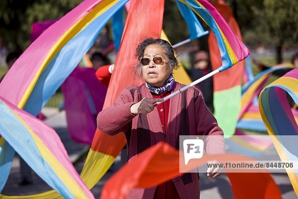 Woman practises tai chi dancing with ribbons in park of the Temple of Heaven  Beijing  China