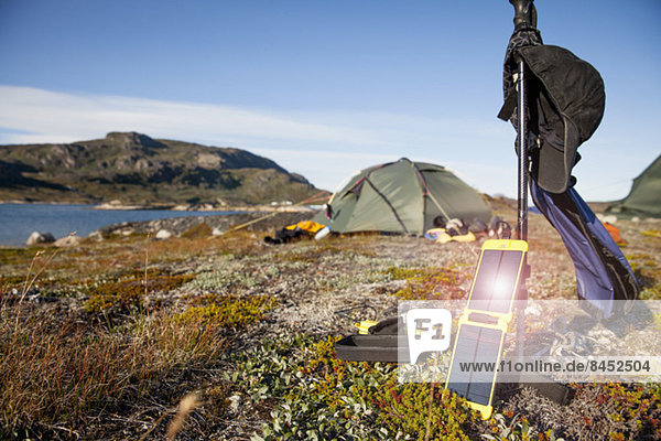 Solarladegerät mit Zelt im Hintergrund auf dem Campingplatz