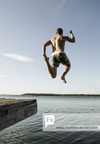 Full length of mature man jumping into sea