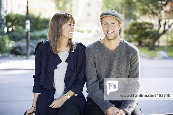 Ein glückliches Paar sitzt im Freien