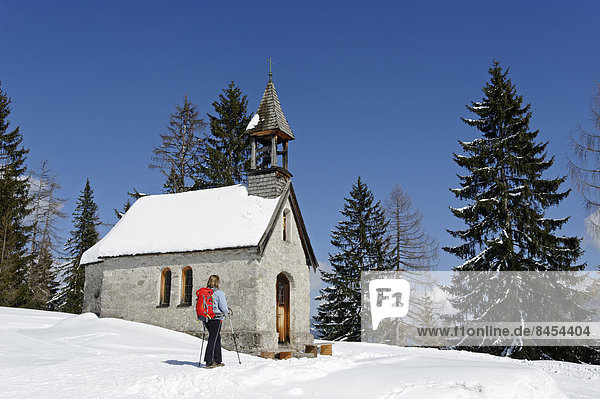 Wanderin im Winter auf der Hemmersuppenalm an der St. Anna Kapelle auf dem Weg zum Fellhorn  Reit im Winkl  Chiemgau  Oberbayern  Bayern  Deutschland