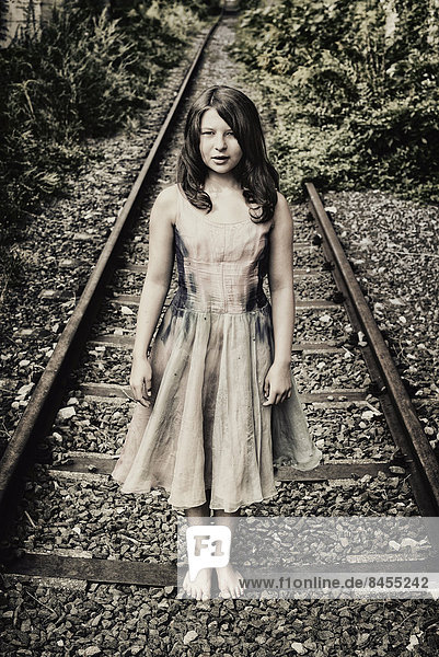 Girl standing on a railroad track
