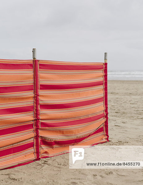 Ein rot gestreifter Windschutz am Cannon Beach an der Küste von Oregon.