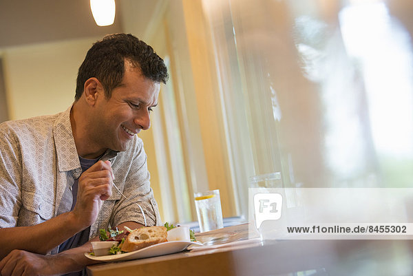 A man eating a snack in a cafe.