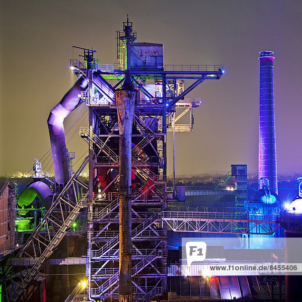 The disused steelworks in Landschaftspark Duisburg-Nord public park on a former industrial site illuminated at night with blast furnace No 2 Duisburg North Rhine-Westphalia Germany