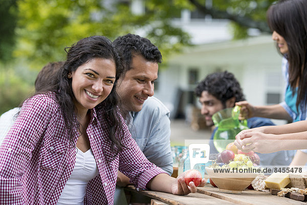 A summer party outdoors. Friends around a table.