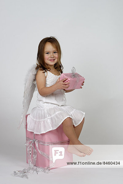 Girl dressed as angel  with Christmas gifts