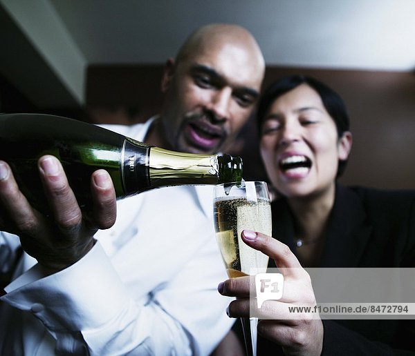 Frau Mann Glas eingießen einschenken jung Champagner
