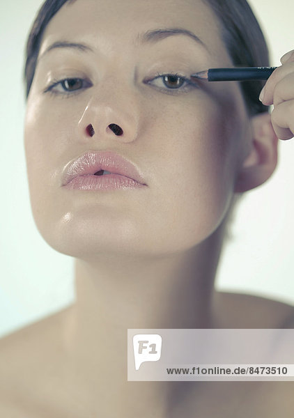eincremen verteilen Frau jung Eyeliner auftragen