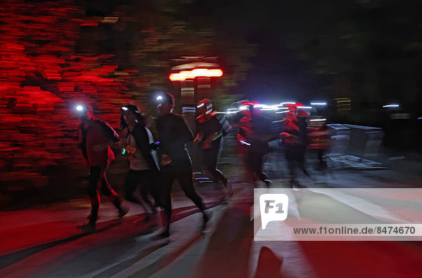 Runners wearing headlamps during a night run  Landschaftspark Duisburg-Nord  landscape park at a disused industrial steel works  Ruhr Area  North Rhine-Westphalia  Germany