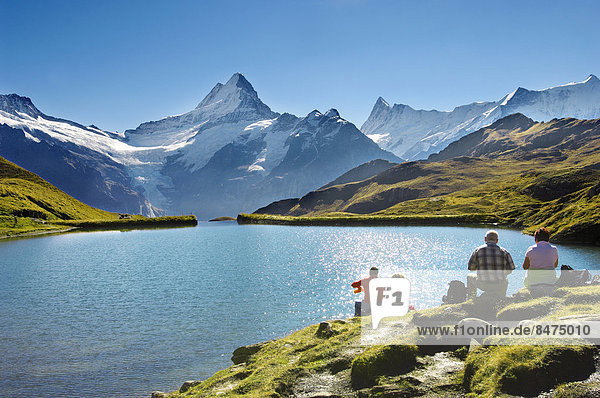 Walkers having a rest next to Bachalpsee lake near Grindelwald First  Swiss Alps  Canton of Bern  Switzerland