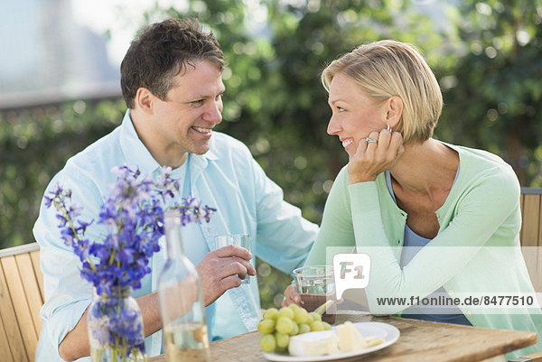 Couple sitting at table outdoors