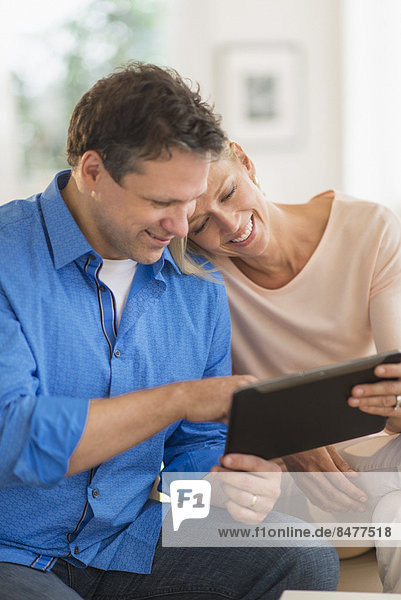 Couple using tablet pc at home